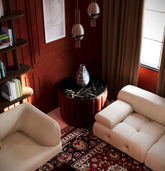 Explore this richly layered lounge by HAUS Living — a bold interior featuring Persian rugs, sculptural furniture, and warm moody walls. For creatives and cultural rebels.