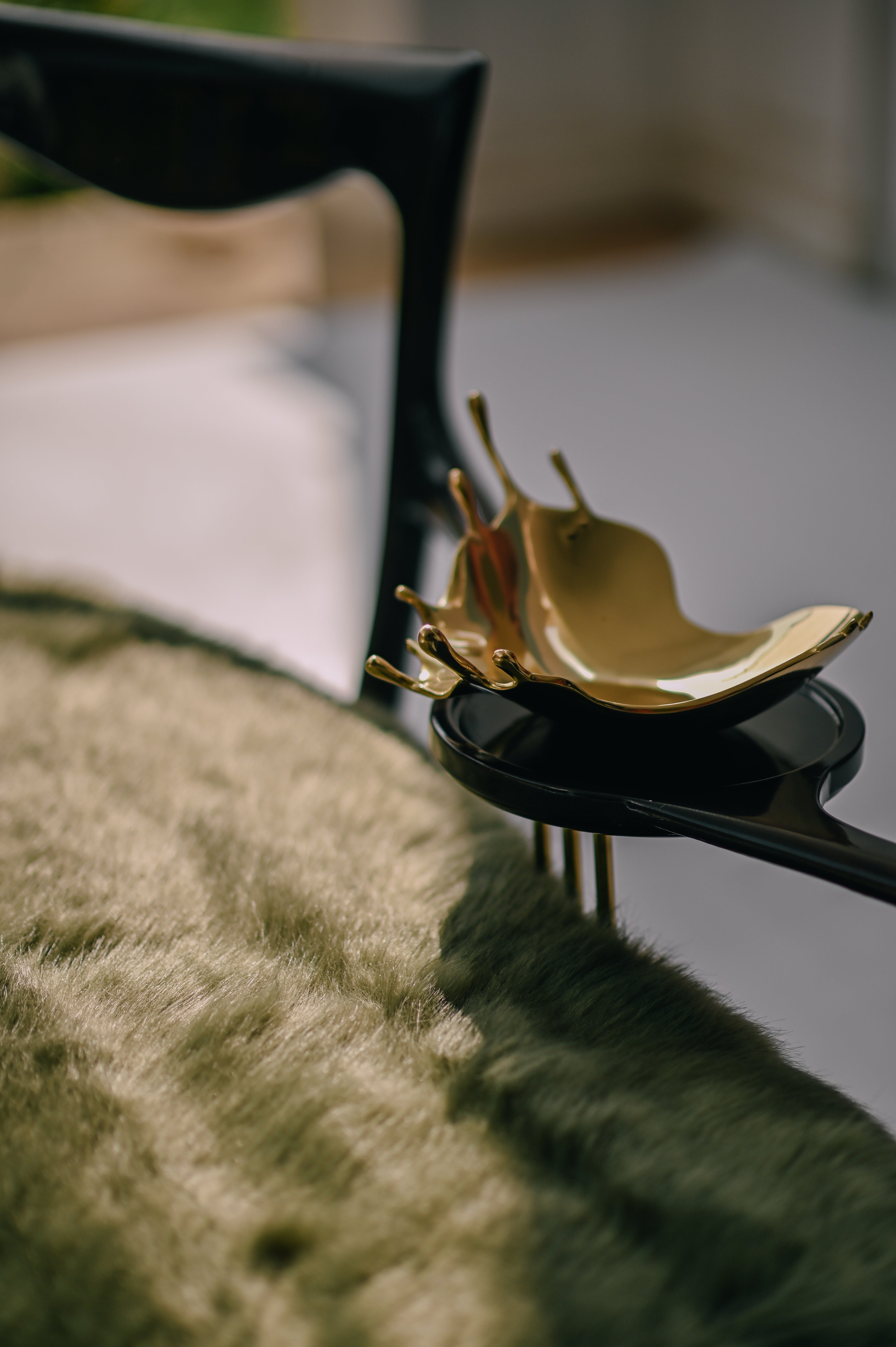 Close-up of high-tactility moss green fur and hand-polished black wood joinery on the ARCHED BACK Bench