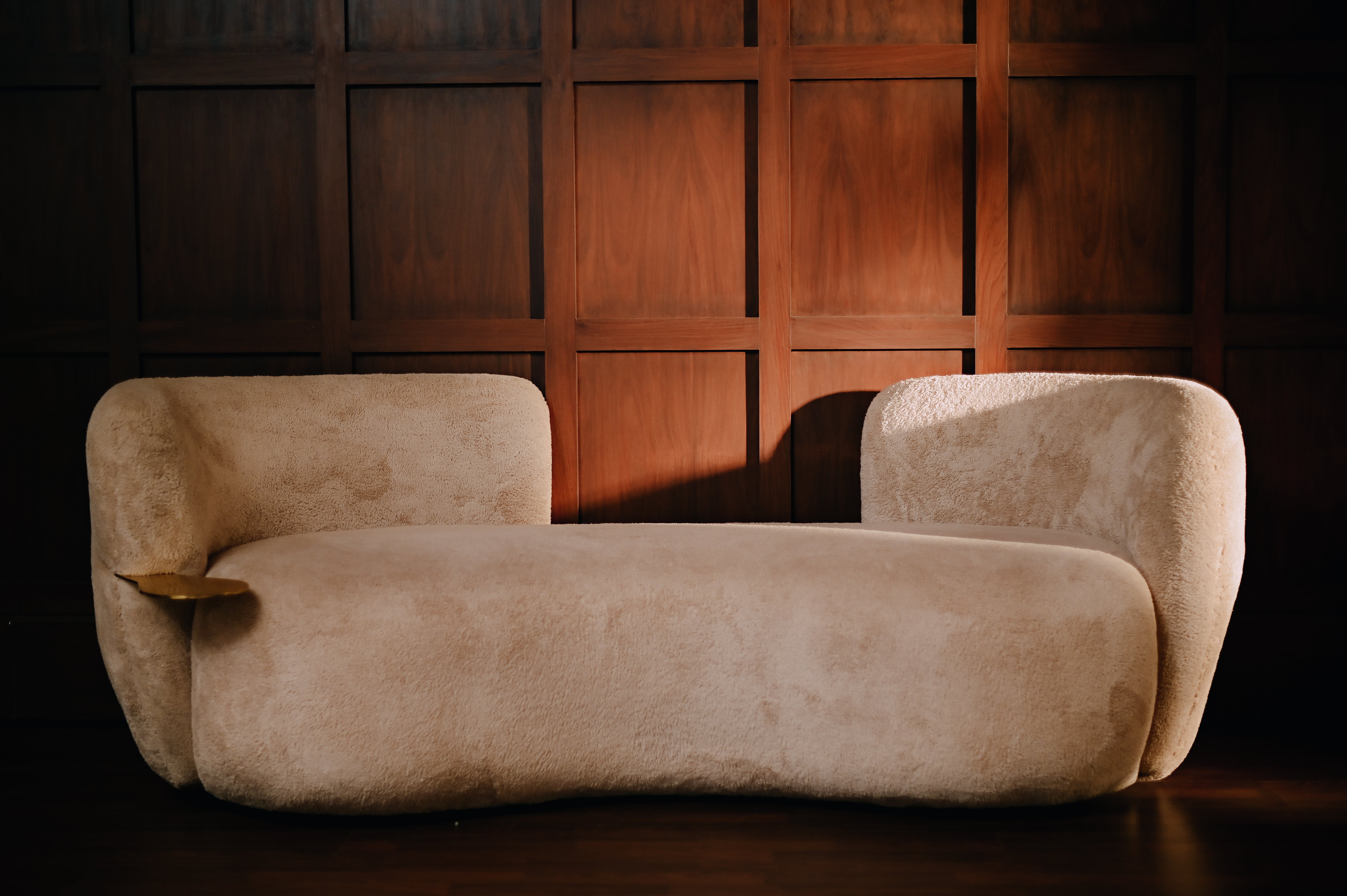 Modern Organic luxury seating from Haus Living featuring a smooth, curved silhouette and hand-cast metallic detailing by Ali Khan Studio