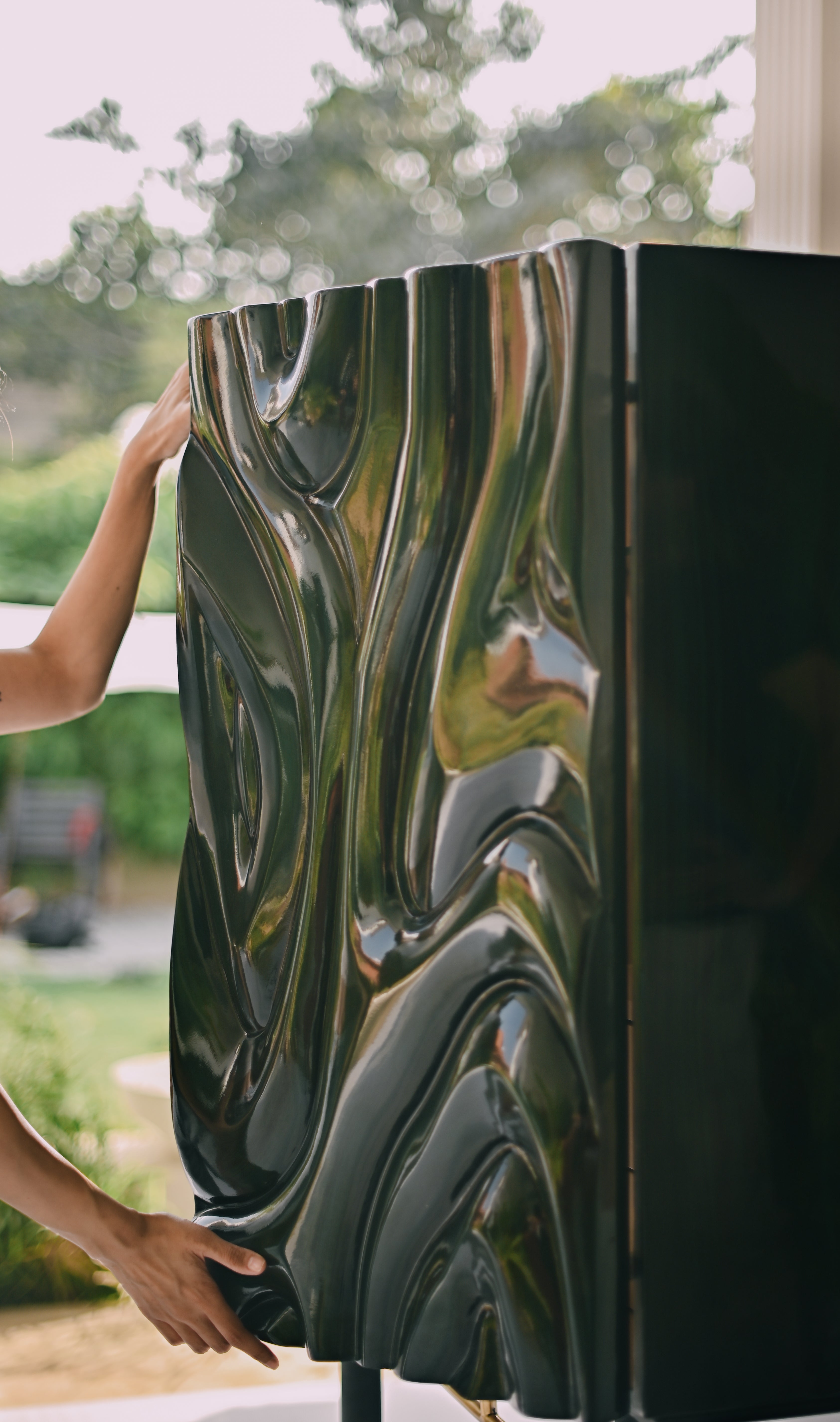 Intricate relief carving on a charcoal-stained furniture facade by Ali Khan Studio, showcasing modern organic patterns and intelligent detailing.