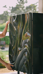 Intricate relief carving on a charcoal-stained furniture facade by Ali Khan Studio, showcasing modern organic patterns and intelligent detailing.